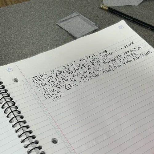 Greek script on notebook - teleconference with Greece