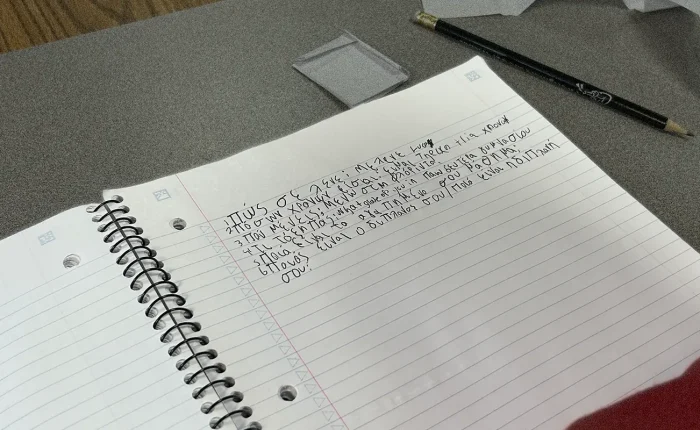 Greek script on notebook - teleconference with Greece