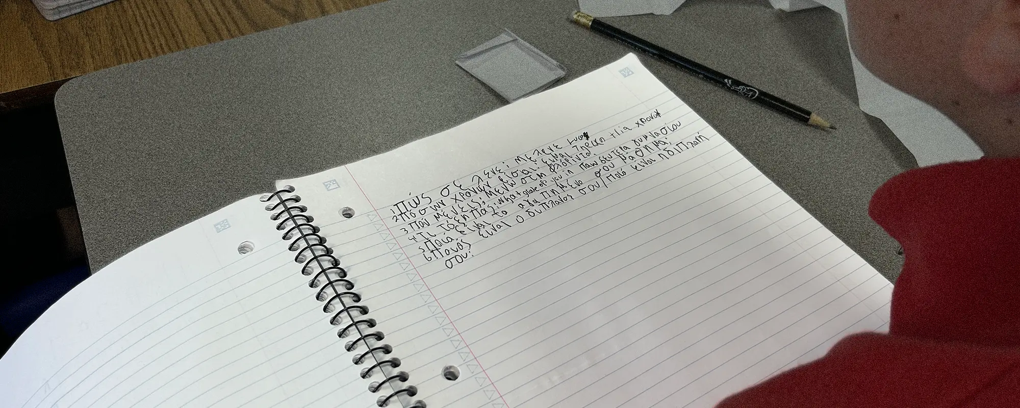 Greek script on notebook - teleconference with Greece