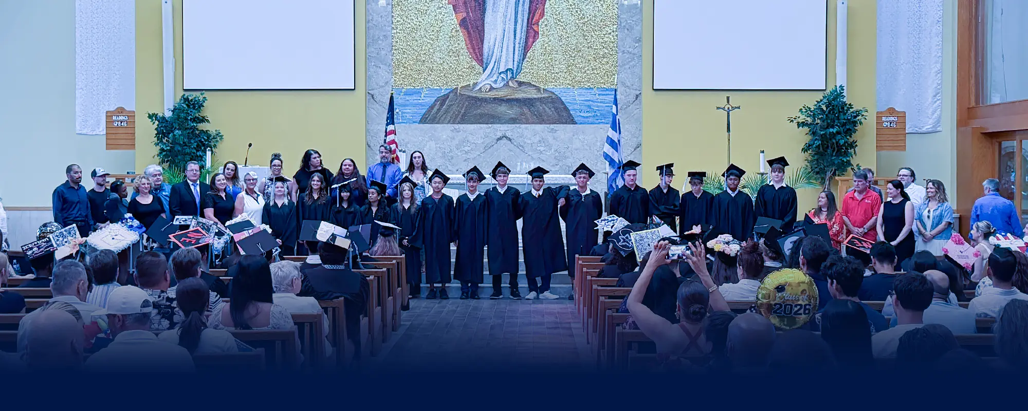 Eighth grade graduates at Plato Academy Pinellas Park standing on stage at their 2026 graduation ceremony with teachers and staff, representing school community, charter school education, and student achievement in Pinellas County, Florida.
